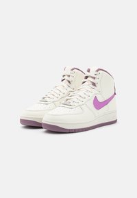 Vysoké tenisky vyrobené z bílé kůže s texturovaným povrchem, vybavené fialovým logem Nike, tkaničkami a fialovou gumovou podešví.