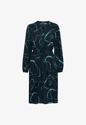 Sötétzöld ruha hosszú ujjal, gombos elülső résszel, megkötős derékkal és folyékony vonalvezetéssel, amelyet világosszöld absztrakt minták díszítenek.
