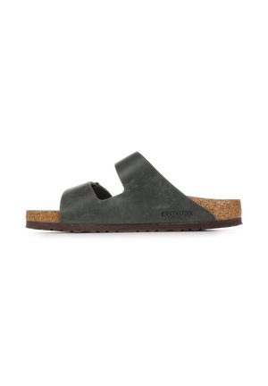 Sandalo con suola in sughero marrone e tomaia in pelle verde scuro, caratterizzato da due fasce larghe e dal logo Birkenstock sul lato.