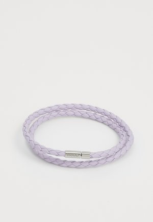Pulsera de cuero trenzado morado con un cierre de metal de tono plateado suave, que presenta el nombre de la marca grabado en el cierre.