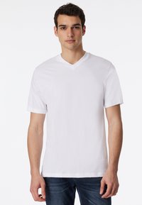 Hvid kortærmet t-shirt med V-udskæring, lavet af glat stof, med en afslappet pasform og uden synlige mønstre eller logoer.