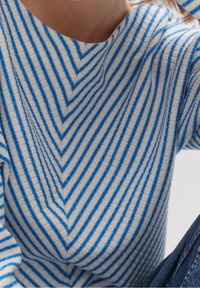 Niebiesko-biały sweter w paski z wzorem w jodełkę, wykonany z teksturowanej tkaniny, o luźnym kroju i szerokim dekolcie.