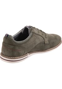 Scarpe verde scamosciato con lacci, design perforato, suola bianca a contrasto e dettagli in cuciture rosse. Presentano una finitura testurizzata e colletto imbottito.