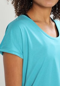 Turkos kortärmad t-shirt tillverkad av mjukt, lätt material med avslappnad passform och rund halsringning.