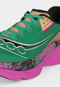Zelená a béžová běžecká bota s růžovo-černě vzorovanou podrážkou, tyrkysovými tkaničkami, prodyšným síťovaným svrškem a nápisem „Endorphin Pro“ u límce.