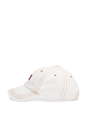 Hvid bomuldsbaseballkappe med brun syning, en buet skygge, broderet logo på siden, og ventilationsøjer.