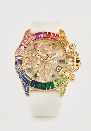 Gold-tone Guess wristwatch with white strap, multicolored gemstones around bezel, and crystal-studded dial with three subdials and date display.