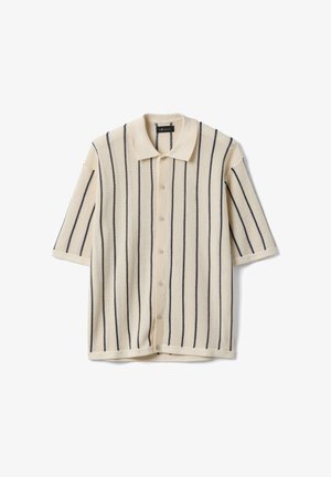 Cardigan de punto de manga corta en color crema con rayas verticales negras, botones delanteros y un suave cuello puntiagudo.