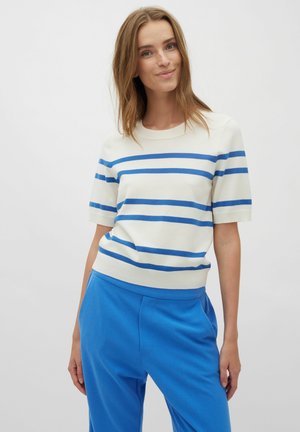 Striped knit sweater in cream with blue stripes, featuring a crew neckline and short sleeves, paired with blue pants. Soft texture, casual design.