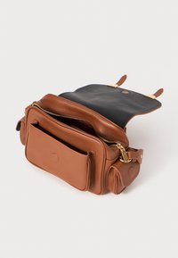 Braune Leder-Crossbody-Tasche mit goldenen Beschlägen, Reißverschlussfächern und einer strukturierten Oberfläche. Innen ist sie mit einem schwarzen Futter ausgestattet und bietet ausreichend Stauraum.