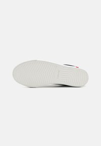 Talpa de sneaker neagră cu fund de cauciuc alb, având o suprafață texturată și numele brandului "Levi's" embosat în design.