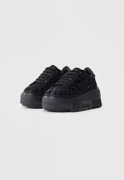 Zwarte platform sneakers met een vetersysteem bedekt met een overlay, een gestructureerde rubberen zool en tonale veters. Accentueert wordt door een logo aan de zijkant.