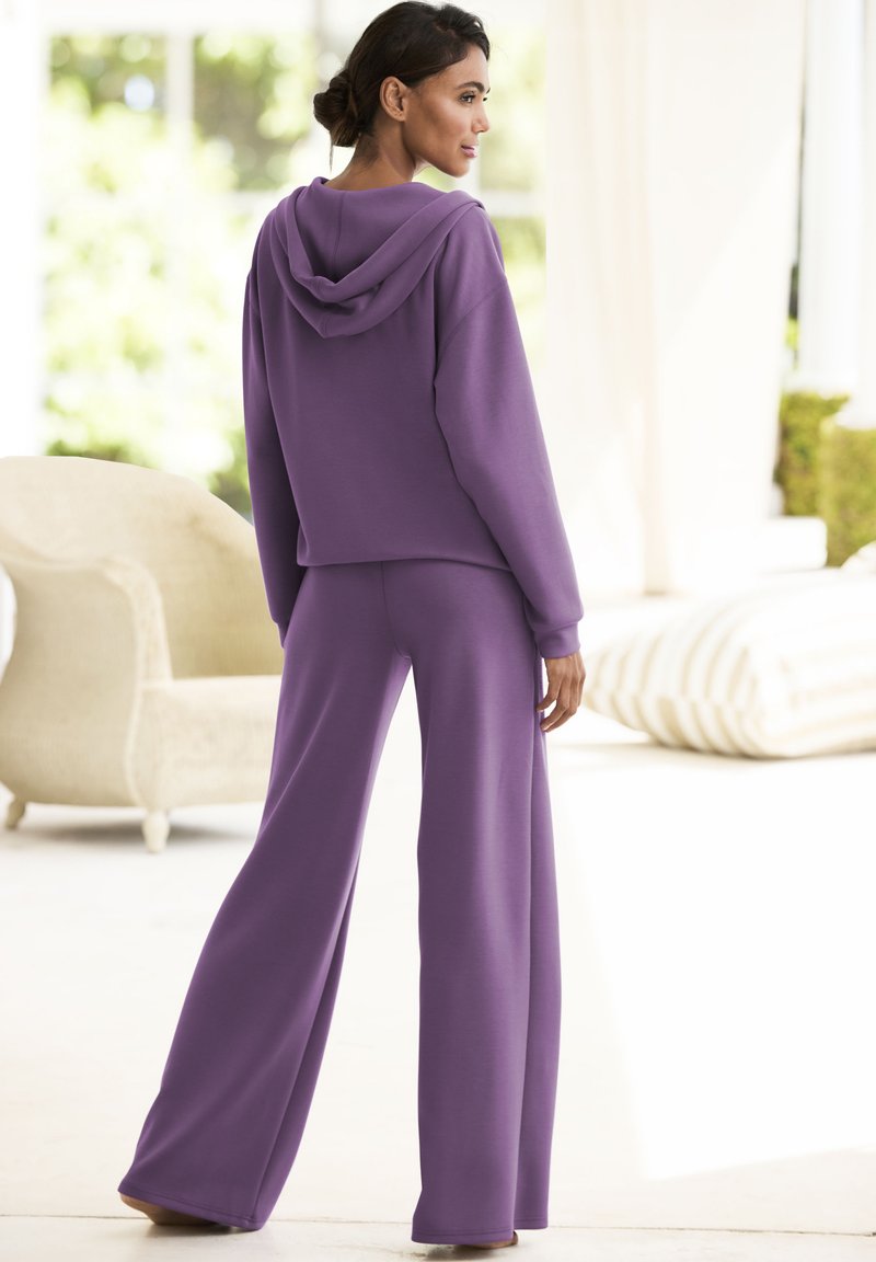 Lila Kapuzenpullover und weite Hose im Set, aus weichem Stoff gefertigt. Verfügt über einen lockeren Schnitt und eine glatte Textur, geeignet für die Freizeit.