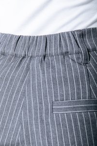 Pantalons gris à rayures fines en tissu texturé, avec une taille plate et une poche sur le côté droit.