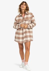 Gekruiste overshirt in crème en roest, met knoopsluiting aan de voorkant, borstzakken en een ontspannen pasvorm. Zachte,Textuurstof met een kraag en lange mouwen.