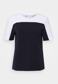 Top a maniche corte con scollatura rotonda; presenta un design a blocchi di colore in blu navy e bianco; tessuto morbido; struttura minimalista; senza hardware visibile.
