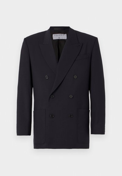 Blazer double boutonné marine en tissu lisse, doté de deux poches avant, de six boutons noirs et de revers crantés. Doublure intérieure visible.