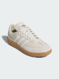 Białe skórzane sneakersy z zamszowymi akcentami, trzy paski po bokach, gumowa podeszwa w kolorze gumy oraz wyściełany kołnierz. Posiadają złote logo na języku.