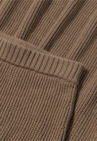 Brauner Strickstoff mit einem gerippten Muster, das horizontale und vertikale Linien aufweist, mit einem weichen, dehnbaren Gefühl und einem entspannten Design.