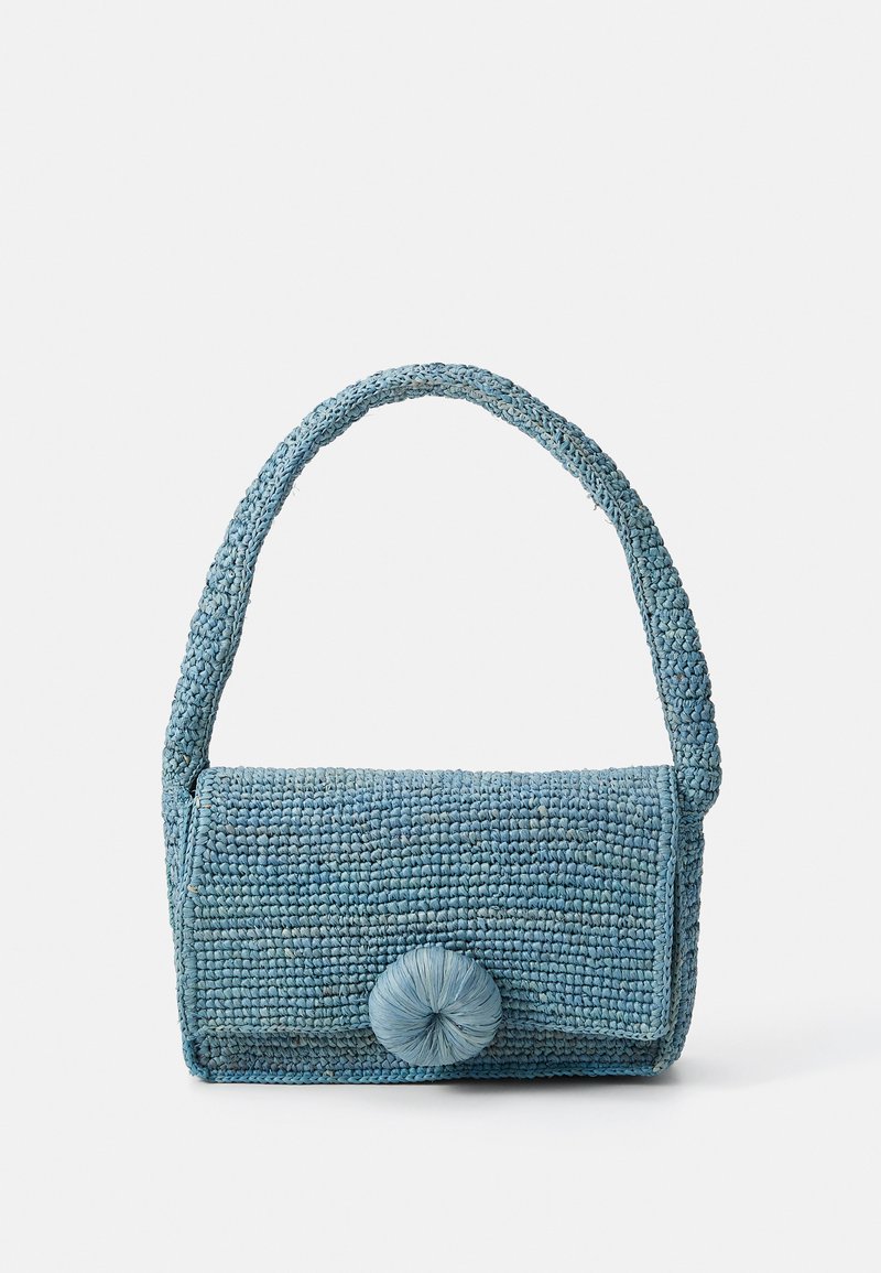 Woven blue handbag with a textured surface, rectangular shape, short handle, and a large round closure detail on the front.