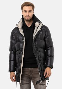 Schwarze Daunenjacke mit glänzender Textur, grauem Innenfutter, mehreren Taschen, hohem Kragen und durchgehendem Reißverschluss.