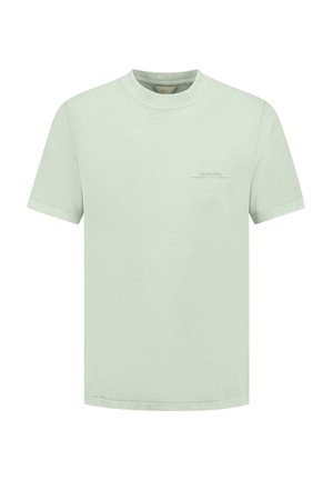 Hele roheline puuvillane T-särk ümmarguse kaelusega ja lühikeste varrukatega. Üleval vasakul küljel on minimaalne teksti trükk.