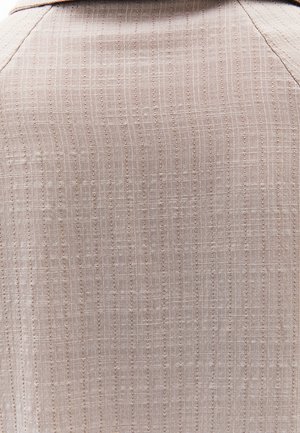 Tejido beige claro con un patrón texturizado de líneas verticales y horizontales, con pequeños y sutiles puntos a lo largo.