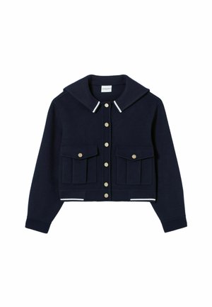 Chaqueta recortada azul marino hecha de tela suave con un amplio collar, botones de presión dorados y dos bolsillos frontales. Presenta acentos a rayas blancas en los puños.