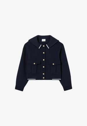 Chaqueta recortada azul marino hecha de tela suave con un amplio collar, botones de presión dorados y dos bolsillos frontales. Presenta acentos a rayas blancas en los puños.