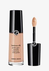 Correcteur en soie lumineuse Giorgio Armani dans un flacon en verre transparent avec un capuchon noir. Il est doté d'un applicateur en forme d'arête de poisson et d'une teinte beige naturel.