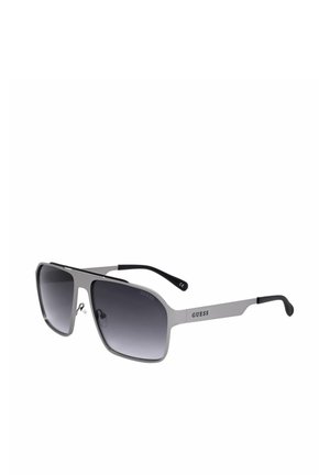 Occhiali da sole Guess color argento con grandi montature quadrate, aste nere e lenti sfumate scure su uno sfondo bianco semplice.