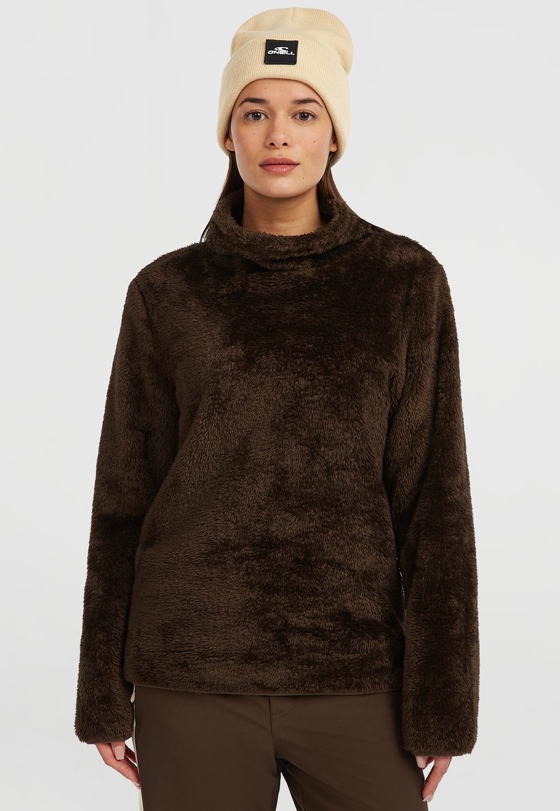 Brun, fyldig fleece-pullover med høj krave og lange ærmer, der har en afslappet pasform. Båret med en beige beanie-hat med logo.