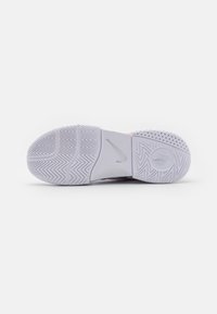 Nike atletska cipela s potplatom u svijetlo sivoj boji, s teksturiranim gumom za prianjanje, s uzorkom riblje kosti i kružnim detaljima za poboljšanu vuču.