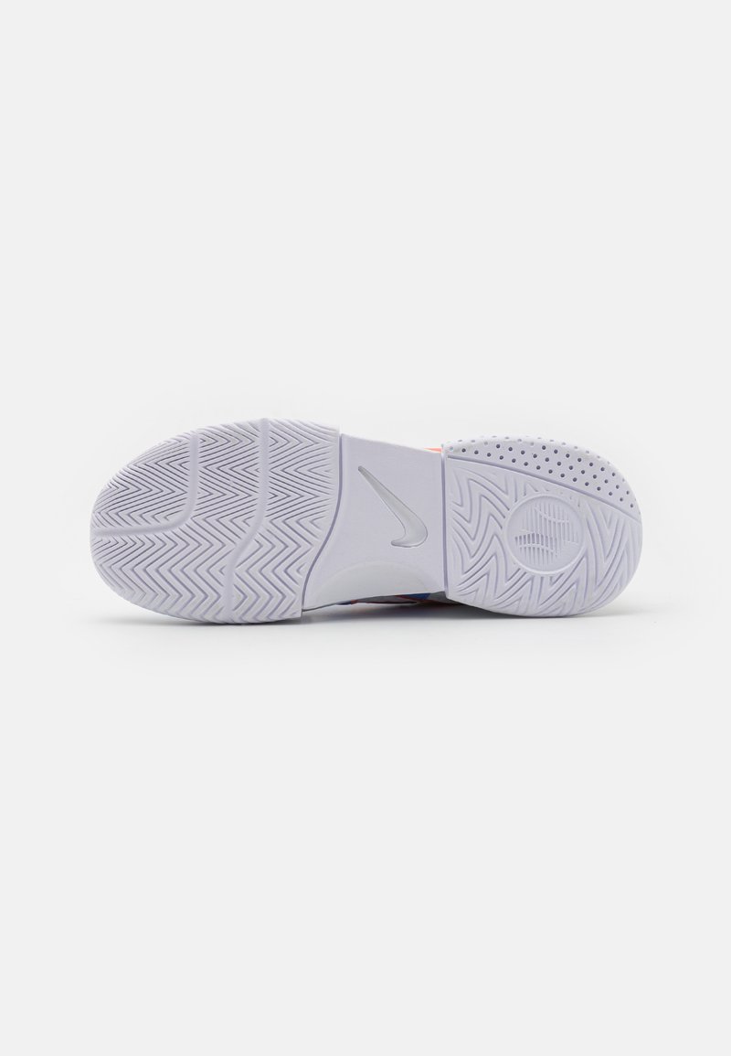 Suela de zapato deportivo Nike en gris claro, con goma texturizada para agarre, que presenta un patrón de espiga y acentos circulares para tracción.