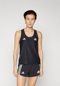 Débardeur de sport noir à design sans manches et col rond, avec logo et accents blancs d'Adidas. Assorti à un short noir.