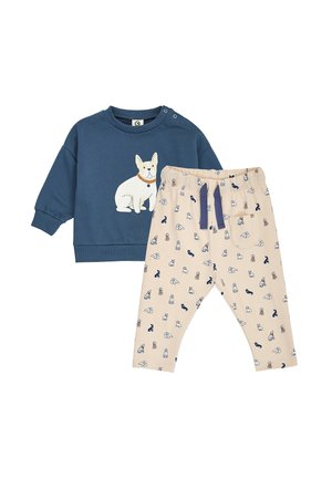 Blå langærmet toddlertrøje med hvid hundegrafik, kombineret med beige bukser med små hundemønstre og en mørkeblå snor.