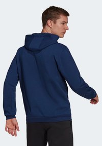 Mørkeblå hettegenser med lange ermer, ribbestrikkede mansjetter og hem, og en klassisk passform. Myk tekstur med et minimalistisk design.