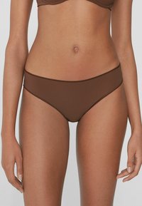 Hnědé bikiny s hladkého, elastického materiálu. Mají nízký pas a decentní švy, bezšvový pas.