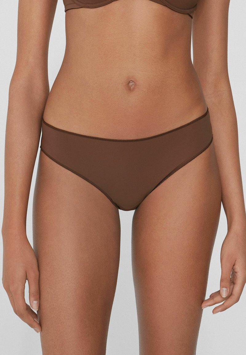 Hnědé bikiny s hladkého, elastického materiálu. Mají nízký pas a decentní švy, bezšvový pas.