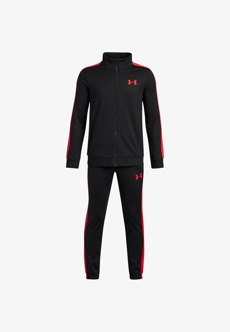 Melnā sporta tērps, kas izgatavots no gludas auduma, ar sarkaniem sānu svītrainiem, augstu apkakli ar rāvējslēdzēju un atbilstošām pieguļošām biksēm ar logotipa akcentiem.