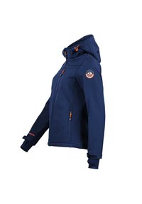 Marineblå softshell-jakke med hætte, med orange lynlåse, sidelommer og et rundt emblem på ærmet; glat tekstur, tætsiddende design.