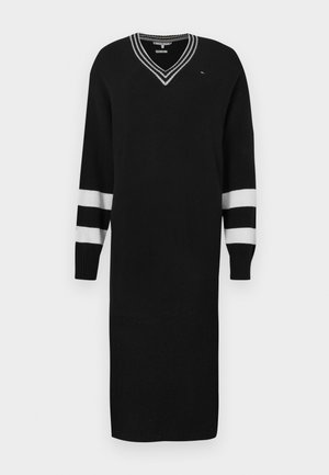 Vestido negro de punto con mangas largas, escote en V y detalles de rayas blancas en las mangas. Textura suave, diseño de longitud media.