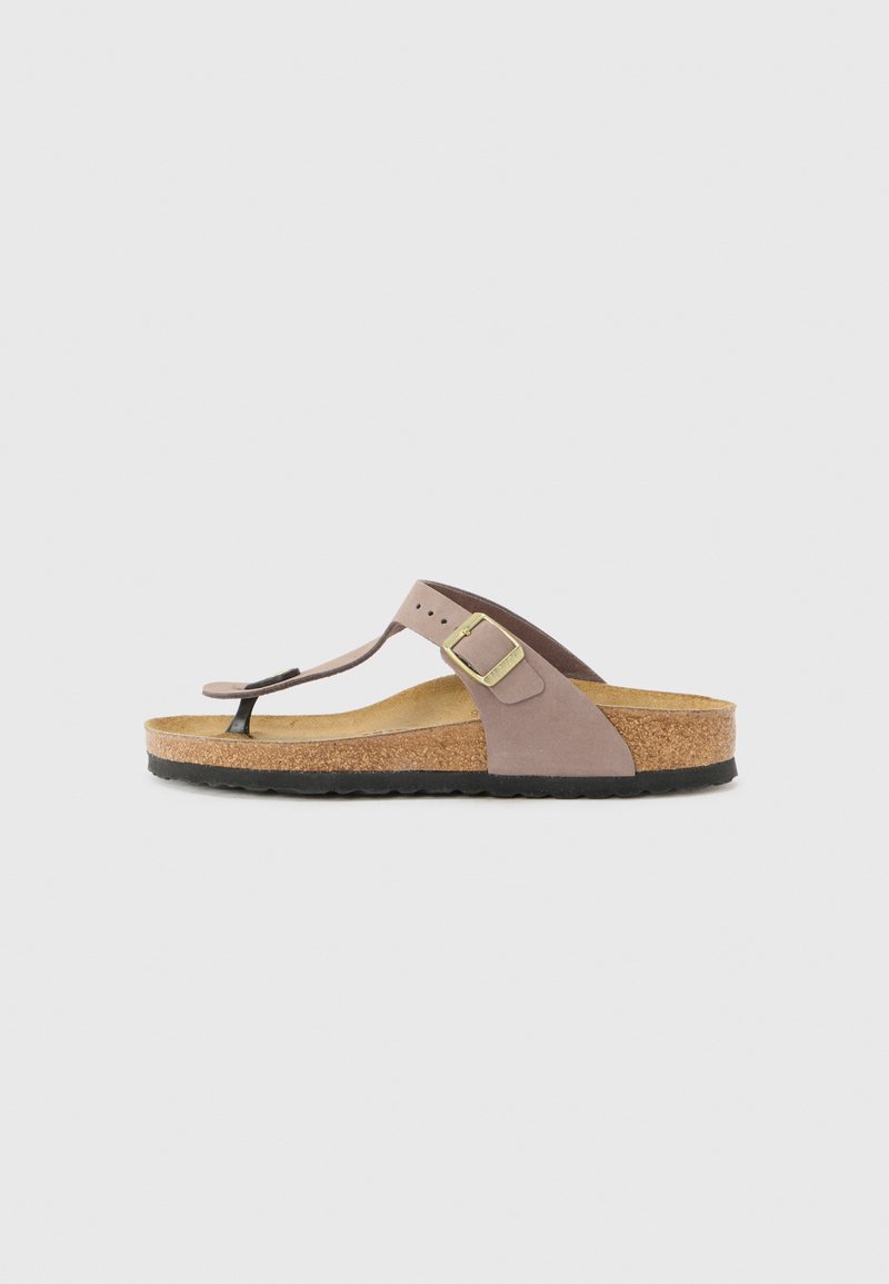 Corksohlen-Sandale mit einem hellbraunen Riemen, schwarzem Zehensteg und einer verstellbaren Schnalle. Sie besitzt eine glatte Oberfläche und ein flaches Design.