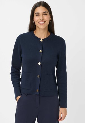 Navyblauwe cardigan van zacht materiaal, met een ronde halslijn, gouden knopen, twee voorzakken en een getailleerd ontwerp.