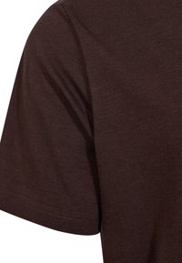 Brun bomulds T-shirt med rund hals og korte ærmer. Stofstrukturen er glat med minimal sømdetalje langs kanten.