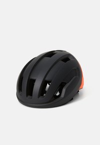 Casco de ciclismo negro con acabado mate, múltiples ranuras de ventilación y un distintivo acento naranja en la parte trasera. Forma redondeada.