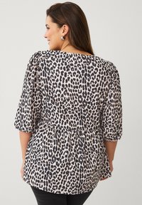 Leopardprint top in beige en zwart, met korte puffmouwen, een ronde halslijn en een gathered taille met peplumdesign.