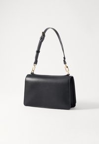 Bolsa de mão em couro preto com uma forma estruturada, uma alça curta e ajustável, e detalhes em metal dourado. Textura suave e design minimalista.