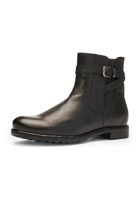 Bottine en cuir noir avec sangle à boucle latérale, panneau élastique et semelle en caoutchouc texturée.