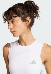 White sleeveless athletic top with a round neck, made from a smooth fabric. Features a gray logo on the left chest area.